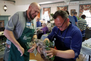 smiling while working on bonsai